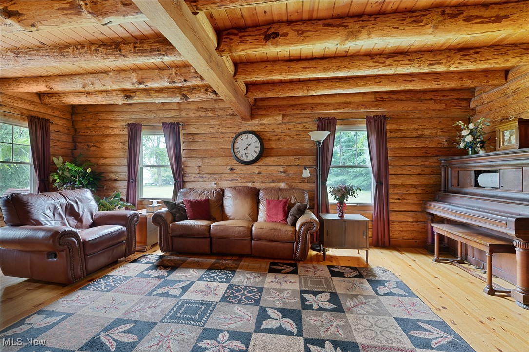 14 Clingan Road Struthers, OH 44471 - Photo 6 of 50 Living area featuring light wood-style flooring, plenty of natural light, rustic walls, and a wood ceiling with exposed beams