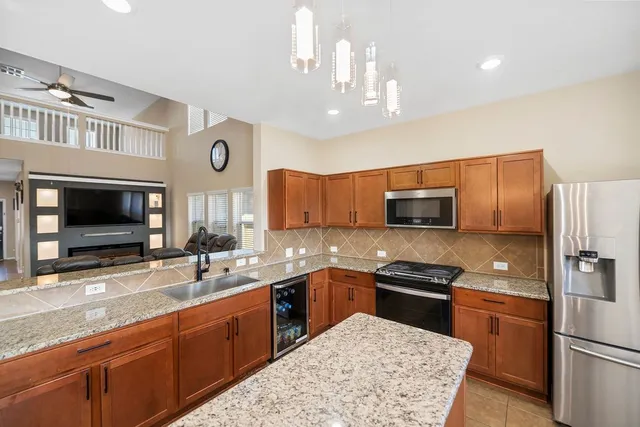 a kitchen with stainless steel appliances granite countertop a sink stove and refrigerator
