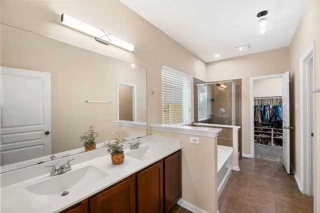 a spacious bathroom with a sink double vanity granite and a mirror