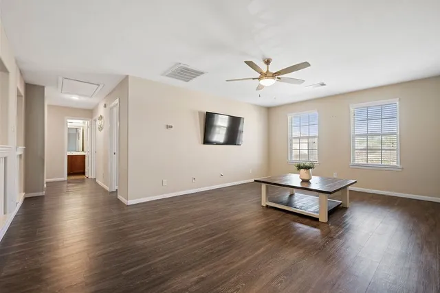 a living room with hard wood floors and a ceiling fan