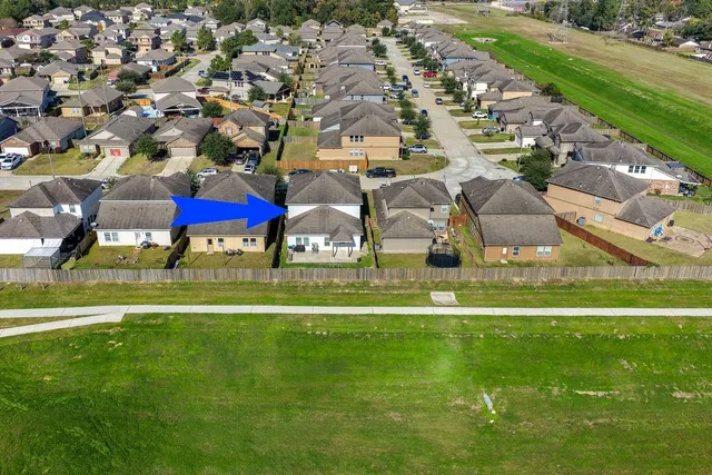 a view of a swimming pool with lawn chairs under an umbrella
