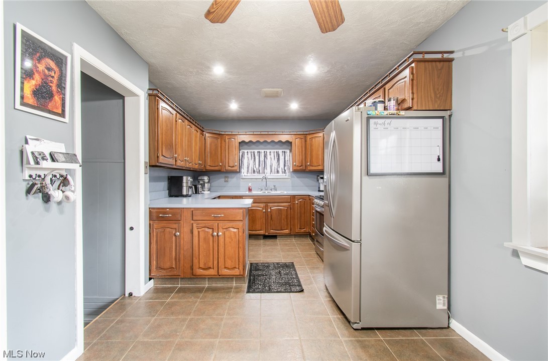 1784 Depot Road Salem, OH 44460 - Photo 6 of 32 Kitchen featuring appliances with stainless steel finishes, light tile floors, ceiling fan, and sink