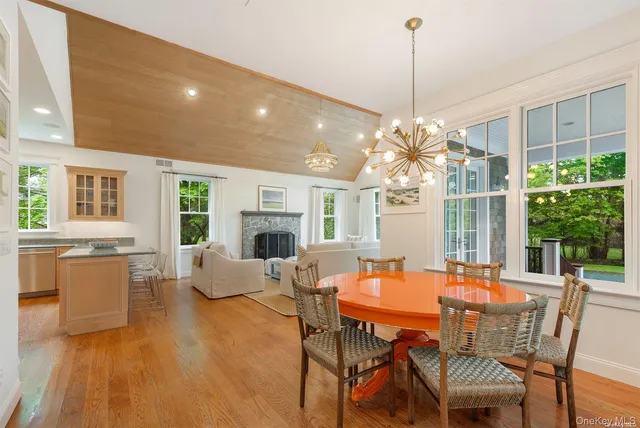 a dining room with furniture a chandelier and wooden floor
