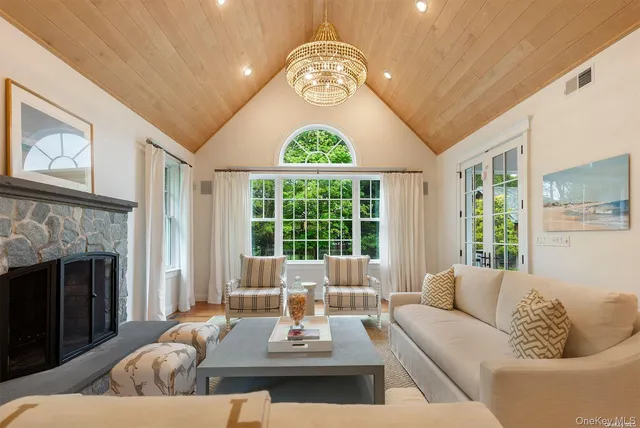 a living room with furniture a chandelier and a fireplace