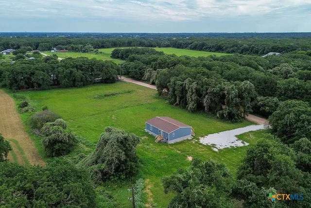an aerial view of a house with pool outdoor seating and yard