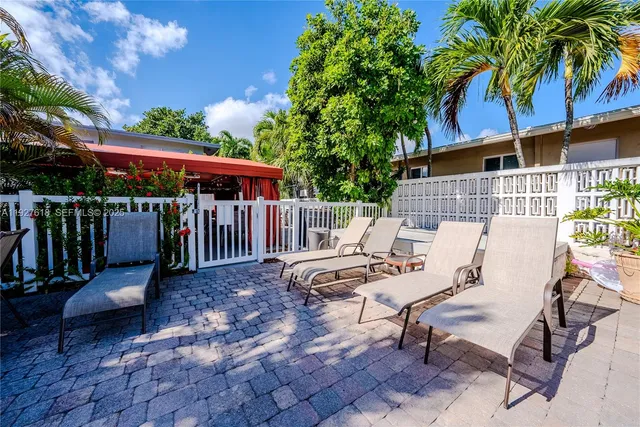 a view of a patio with table and chairs with wooden floor and fence