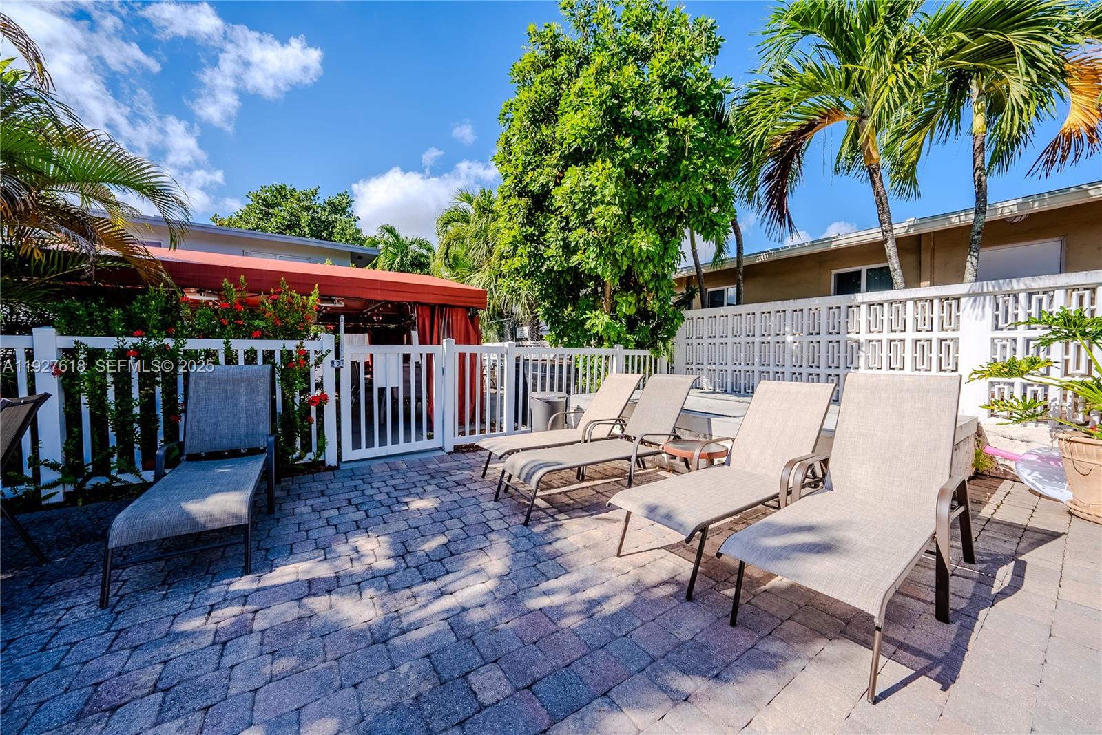 221 Southeast 9th Avenue, Unit 202 Pompano Beach, FL 33060 - Photo 14 of 19 a view of a patio with table and chairs with wooden floor and fence