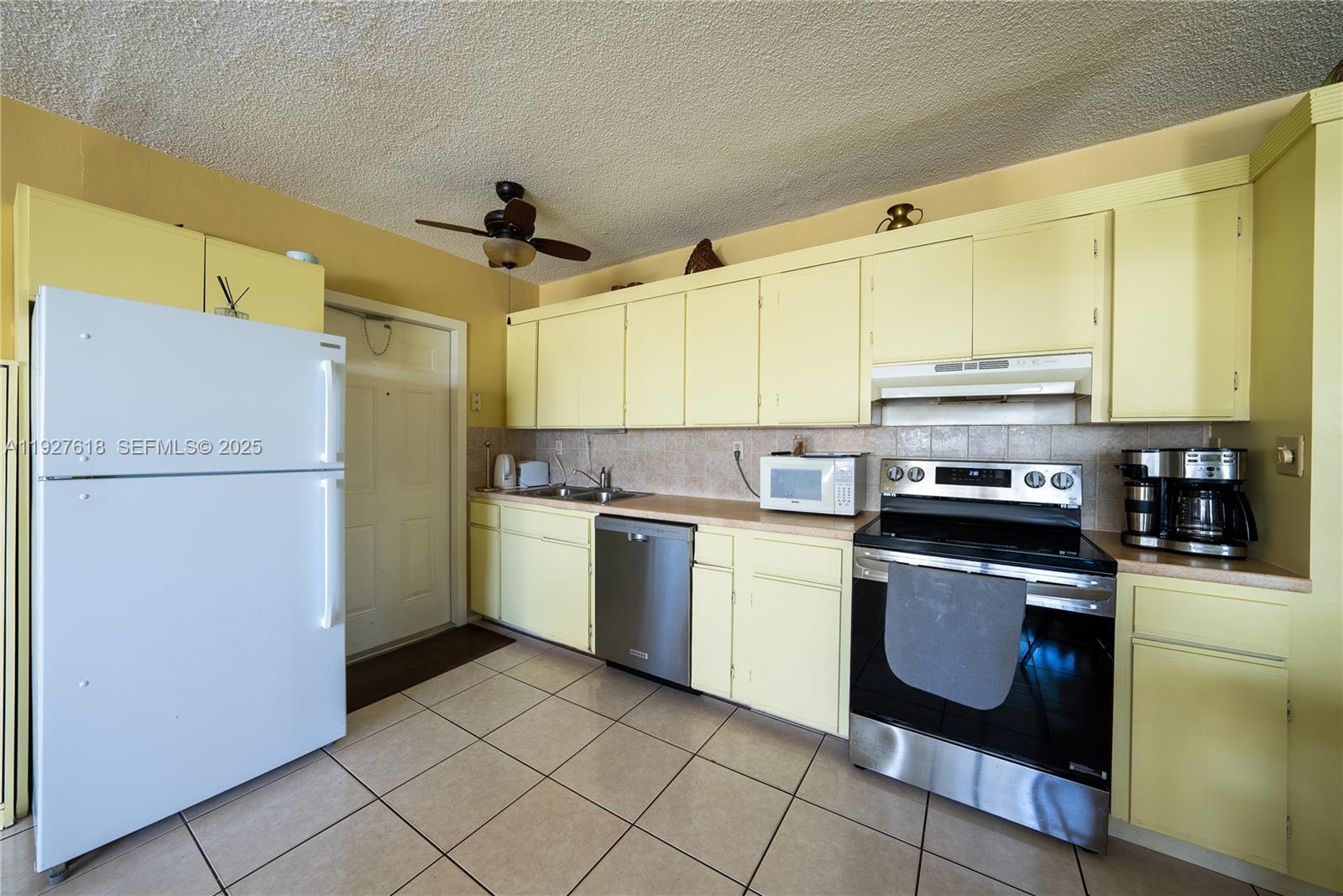 221 Southeast 9th Avenue, Unit 202 Pompano Beach, FL 33060 - Photo 7 of 19 a kitchen with a sink stove and refrigerator