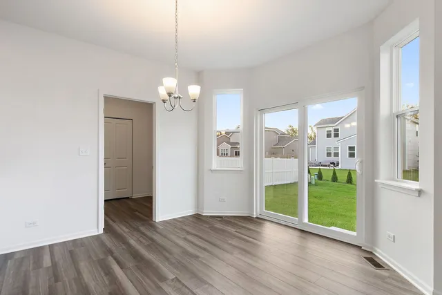 a view of a big room with wooden floor a chandelier and entryway