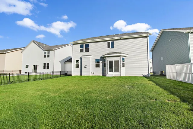 a view of a white house with a big yard and large trees