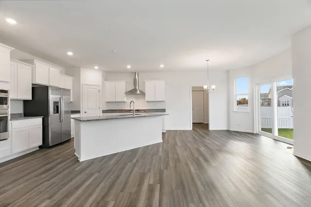 a view of kitchen with refrigerator stove and wooden floor