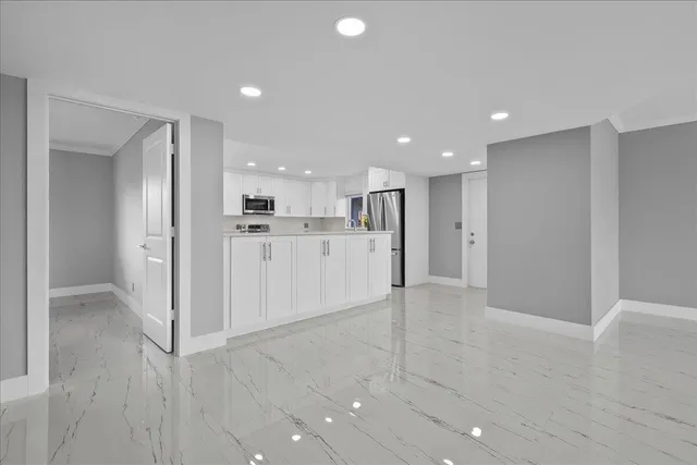 a view of a kitchen with refrigerator and wooden floor