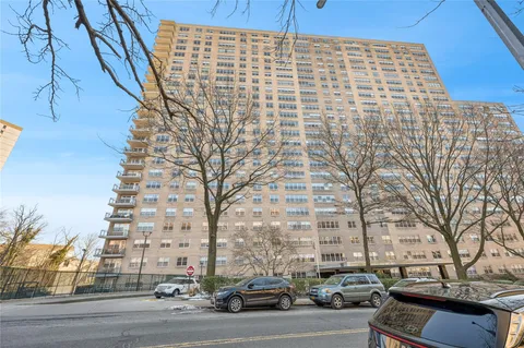 a front view of building with a garden and plants
