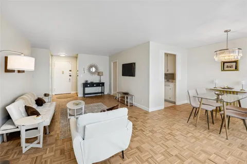 a living room with furniture and a dining table with rug