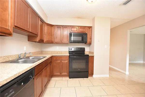 a kitchen with granite countertop a sink and a stove top oven