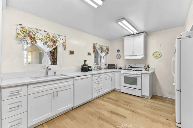 a kitchen with cabinets stainless steel appliances and window
