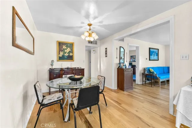 a dining room with wooden floor and chandelier