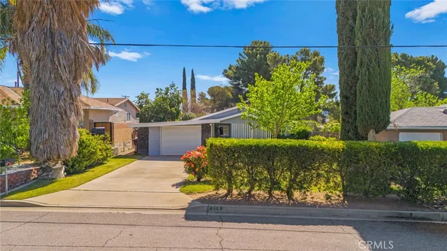 a front view of a house with a yard and potted plants