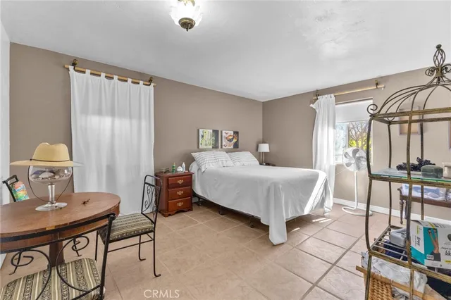 a bedroom with a bed a table and chair