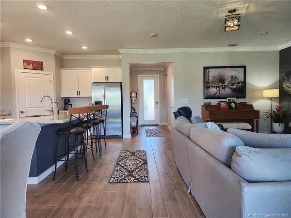 a living room with furniture and a dining table with wooden floor