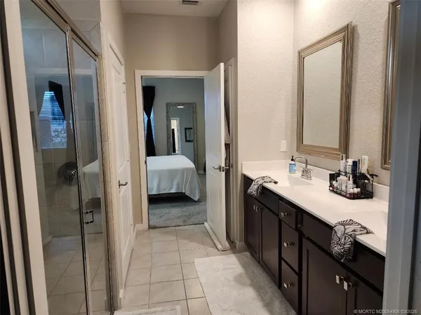 a en suite bathroom with a double vanity sink and a mirror