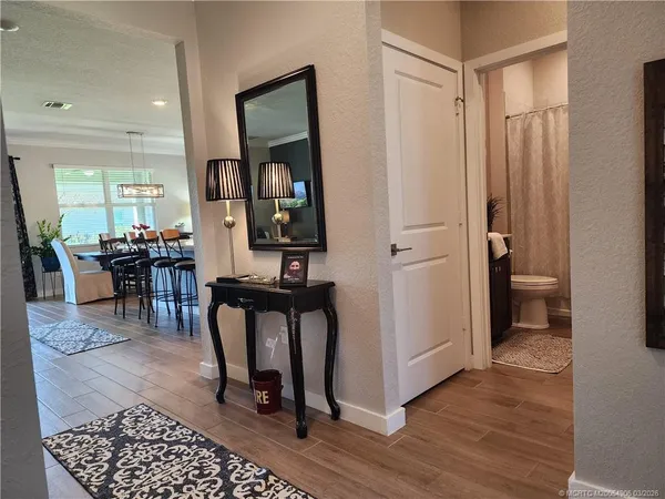 a view of a hallway and dining room with wooden floor