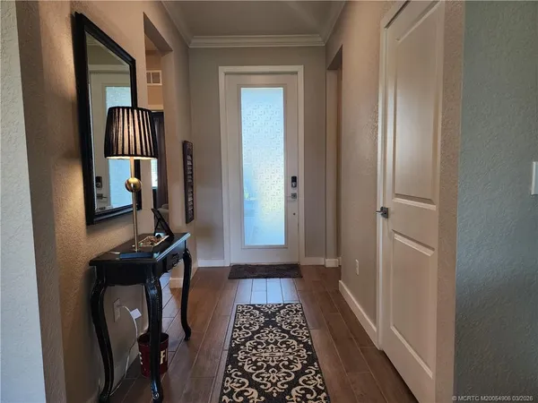 a hallway with front door wooden floor and windows