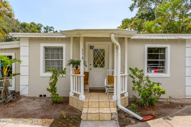 a view of a house with a tree in front of it