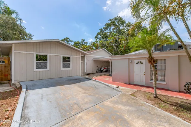 a view of a house with a yard and large tree