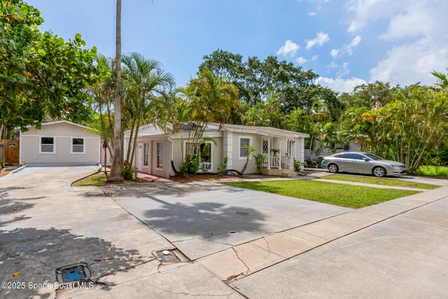 a view of a house with backyard and sitting area