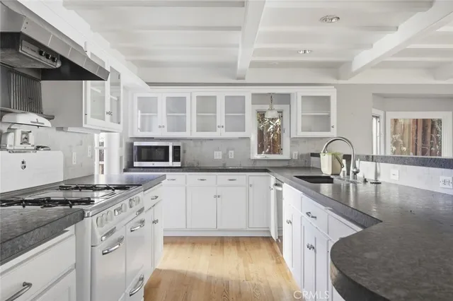 a kitchen with stainless steel appliances granite countertop a stove sink and cabinets