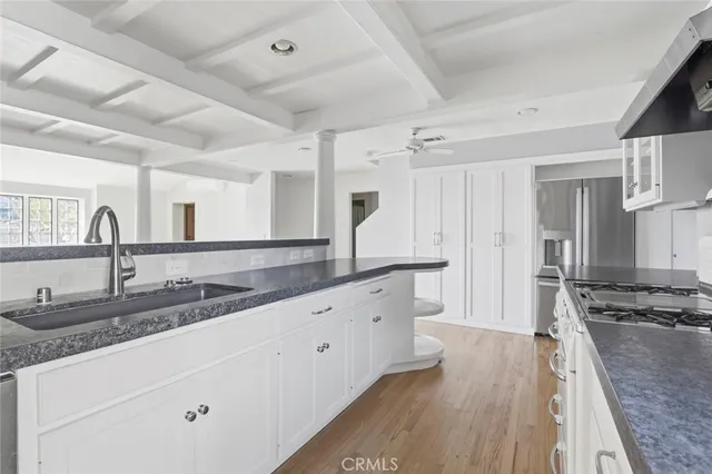 a large kitchen with granite countertop a lot of counter space and wooden floor