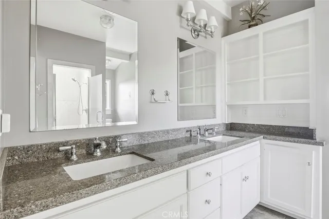 a bathroom with a granite countertop sink and a mirror