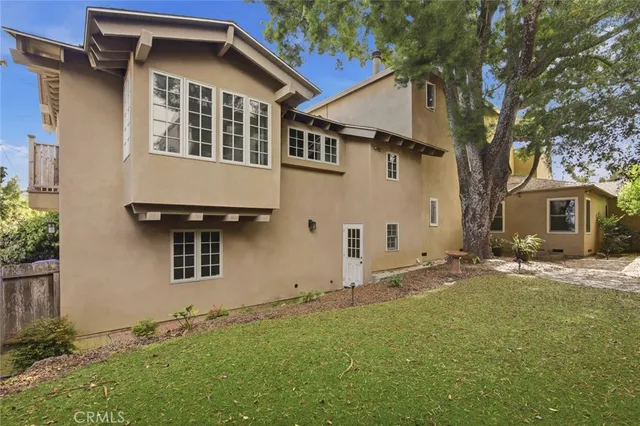 a row of palm trees in front of a house