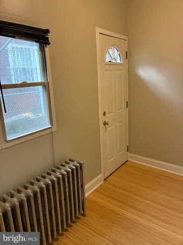 a view of a hallway with wooden floor and entryway