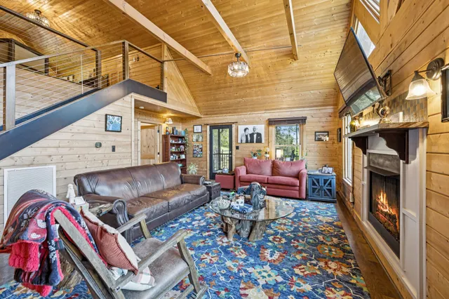 a kitchen with kitchen island granite countertop a refrigerator oven a sink dishwasher and white cabinets with wooden floor