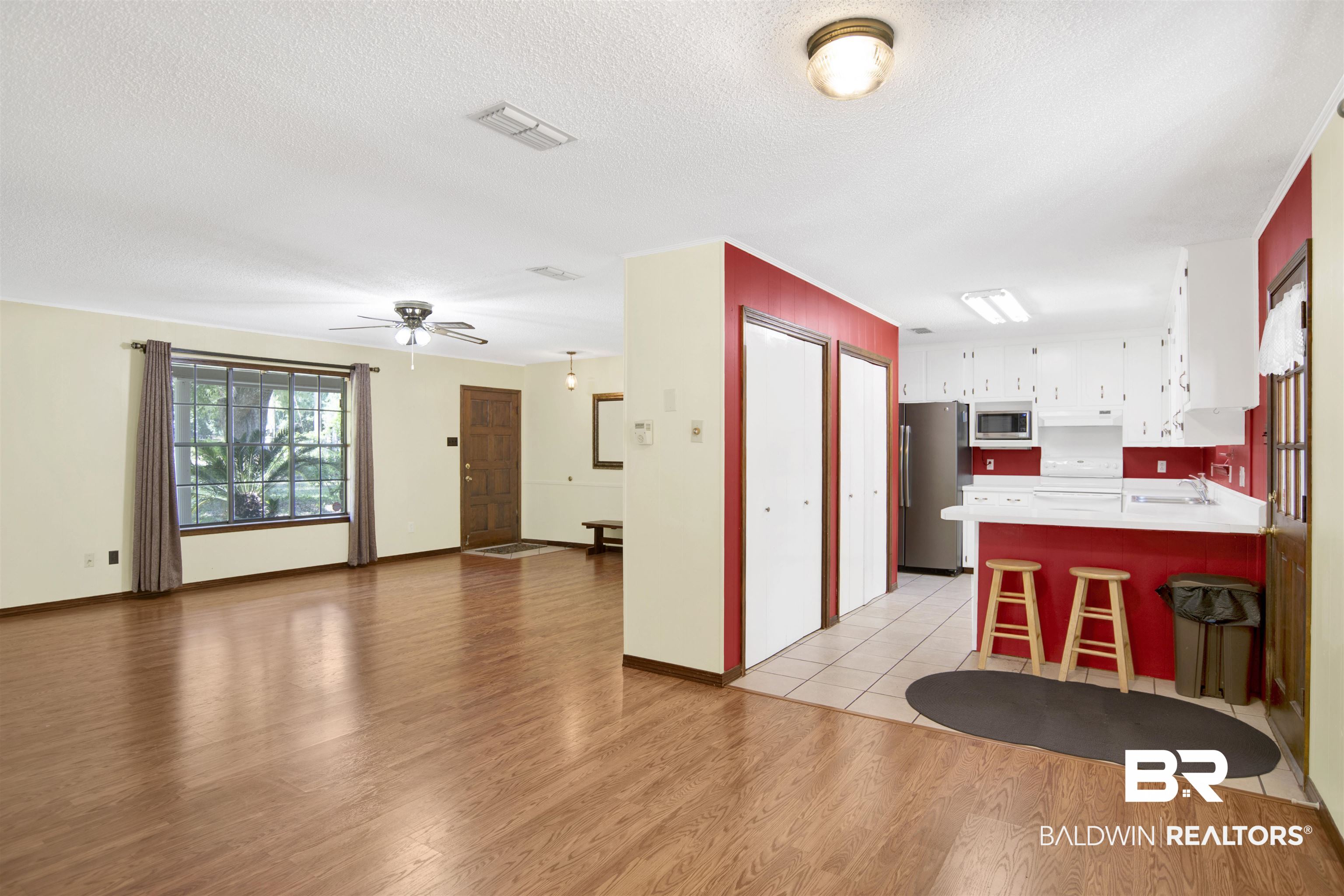 30888 Cemetery Road Daphne, AL 36527 - Photo 9 of 36 Open-concept living space with wood-finish flooring extending into the living area
