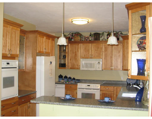 134 Mashapaug Road Sturbridge, MA 01566 - Photo 3 of 30 a kitchen with a refrigerator and cabinets