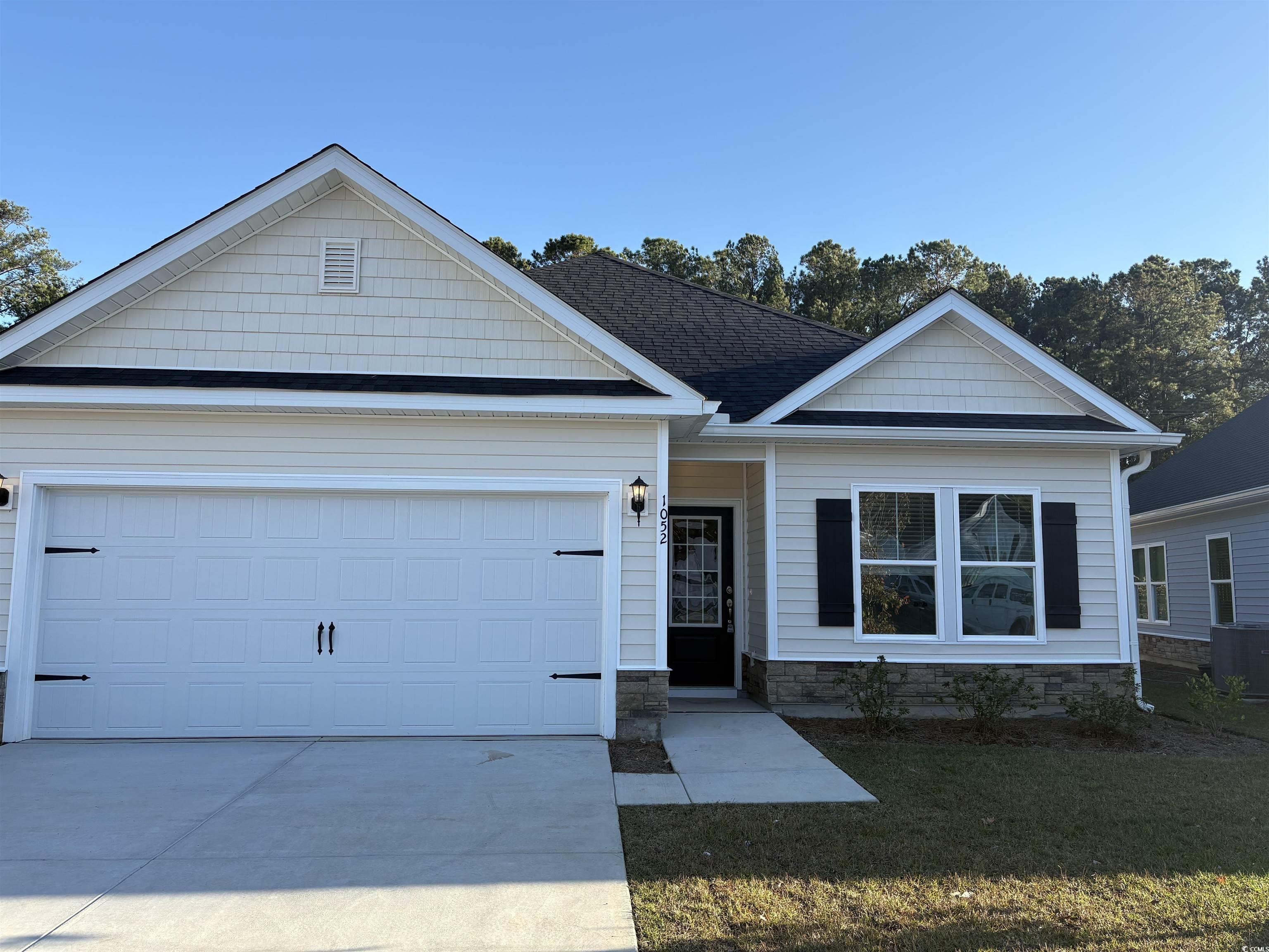 1052 Moen Loop, Unit LOT 14 Conway, SC 29526 - Photo 1 of 24 Single story home with concrete driveway, stone siding, a front lawn, a shingled roof, and an attached garage