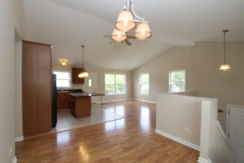 a view of a kitchen with a stove wooden cabinets and a chandelier