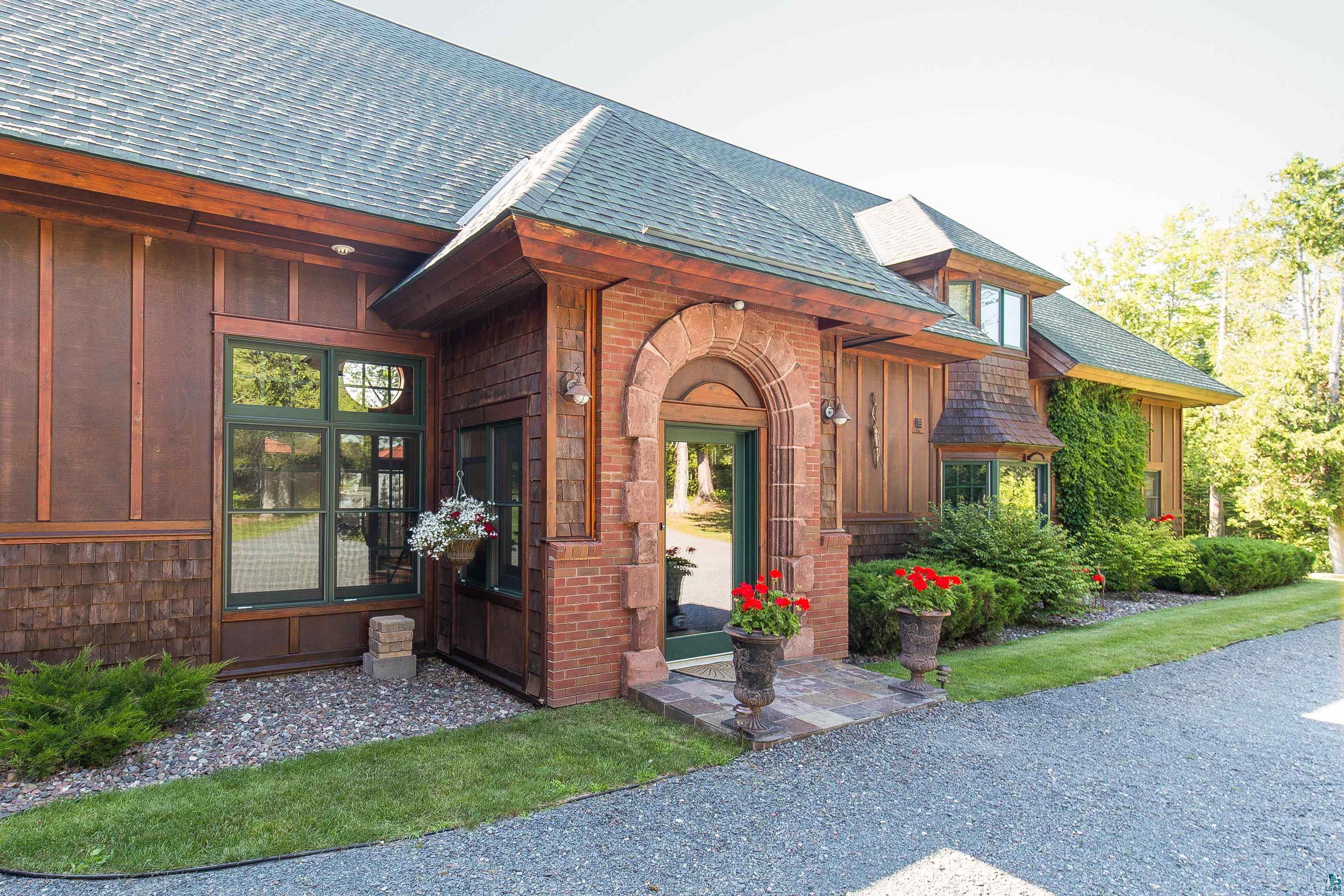 89405 Jack Pine Road Cornucopia, WI 54827 - Photo 13 of 60 Entrance to property featuring roof with shingles, board and batten siding, and brick siding