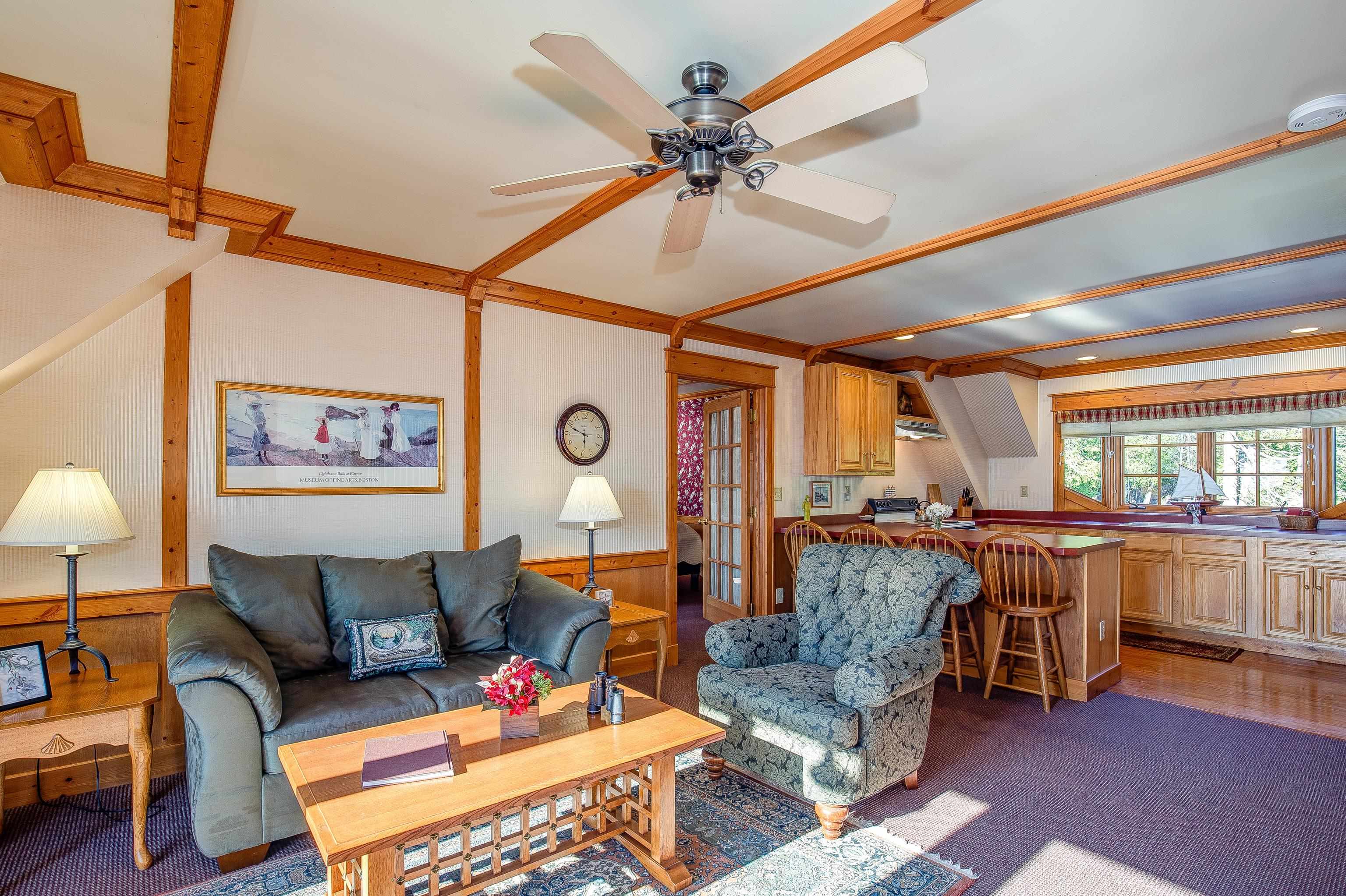 89405 Jack Pine Road Cornucopia, WI 54827 - Photo 45 of 60 Living room featuring a ceiling fan, wainscoting, wooden walls, a dry bar, and carpet flooring