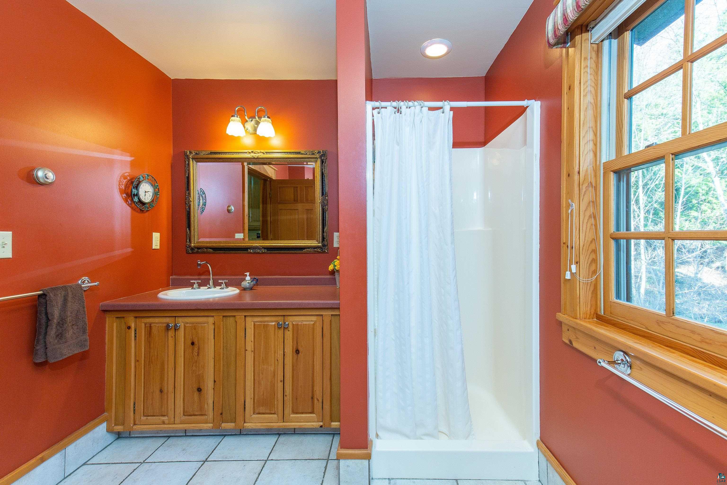 89405 Jack Pine Road Cornucopia, WI 54827 - Photo 48 of 60 Full bath featuring tile patterned floors, a shower with curtain, and vanity