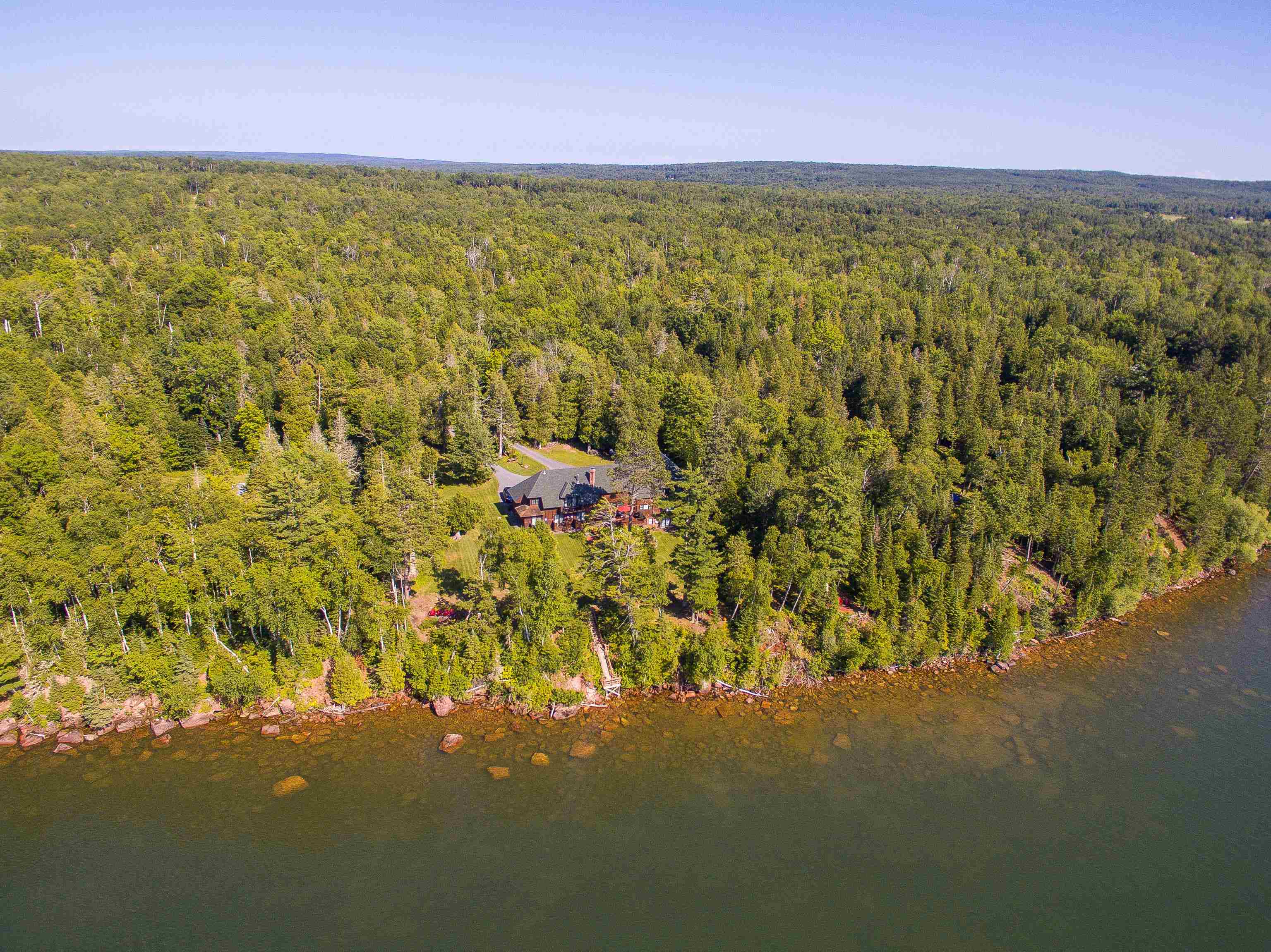 89405 Jack Pine Road Cornucopia, WI 54827 - Photo 5 of 60 Aerial view of a heavily wooded area and a nearby body of water