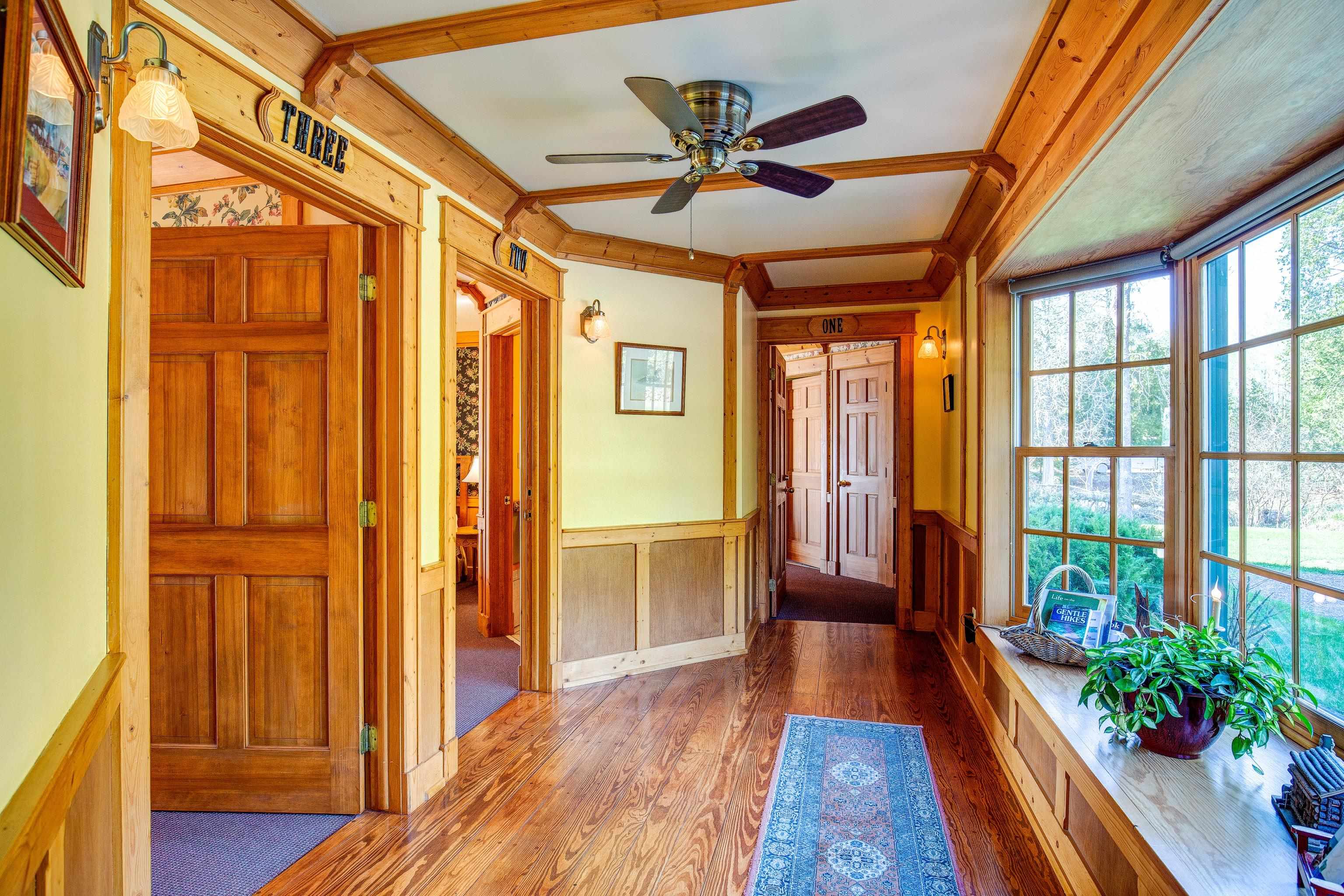 89405 Jack Pine Road Cornucopia, WI 54827 - Photo 57 of 60 Entryway with hardwood / wood-style flooring, a wainscoted wall, a ceiling fan, and ornamental molding
