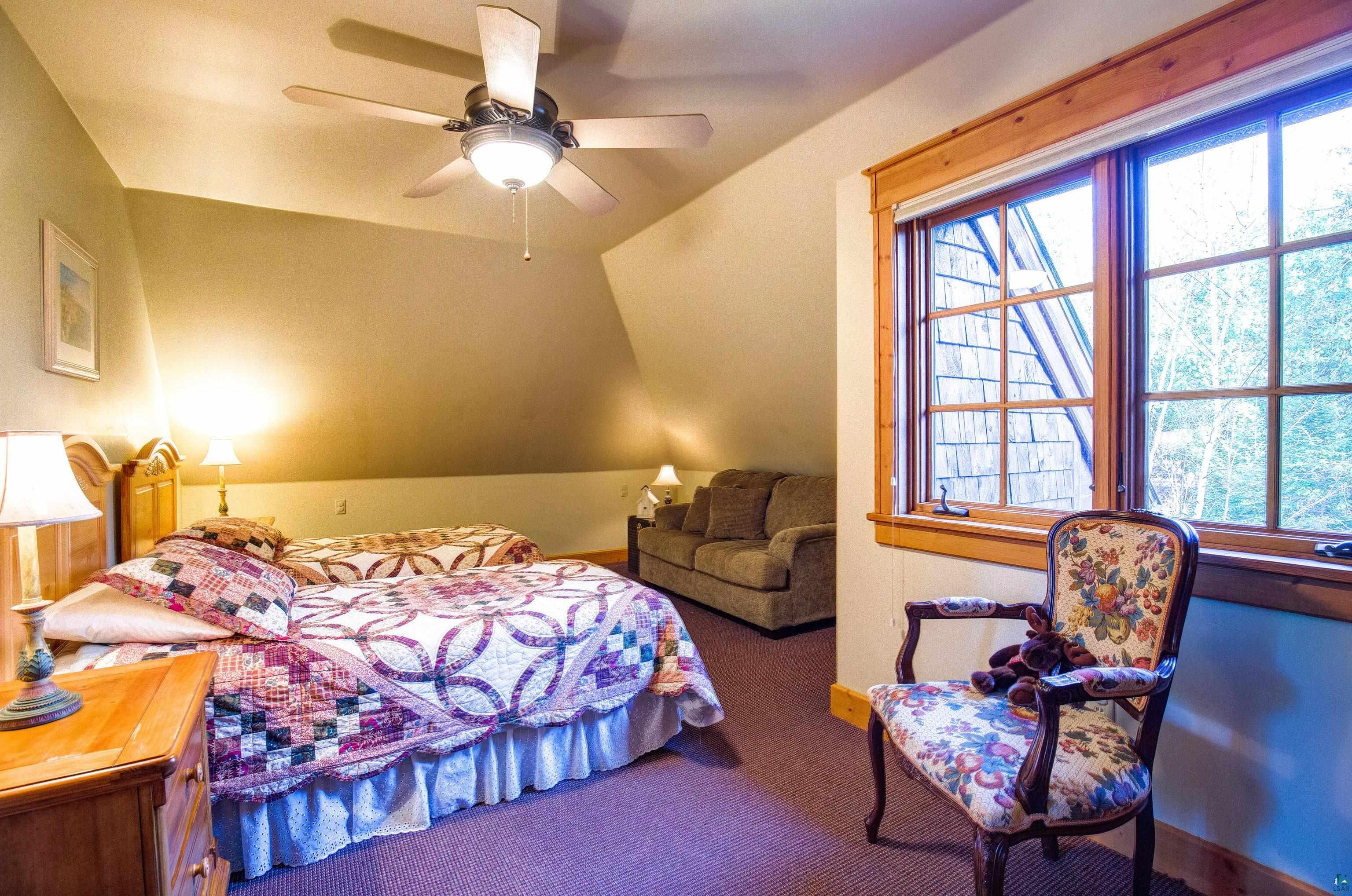 89405 Jack Pine Road Cornucopia, WI 54827 - Photo 58 of 60 Carpeted bedroom featuring lofted ceiling and ceiling fan