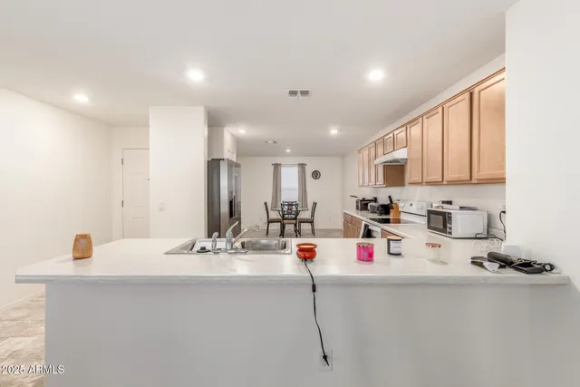 a white kitchen with a sink and white appliances