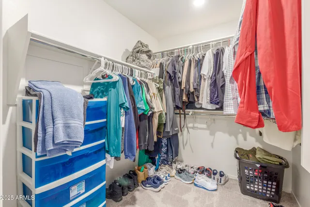 a view of walk in closet with clothes and shoes