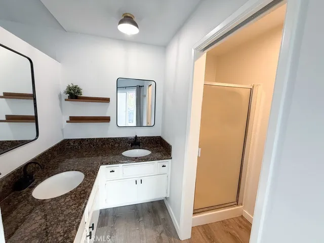 a en suite bathroom with a granite countertop sink and a mirror