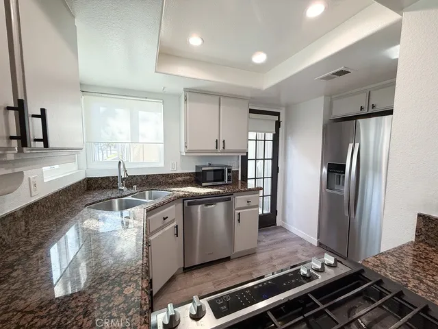 a kitchen with stainless steel appliances granite countertop a stove a refrigerator and a sink